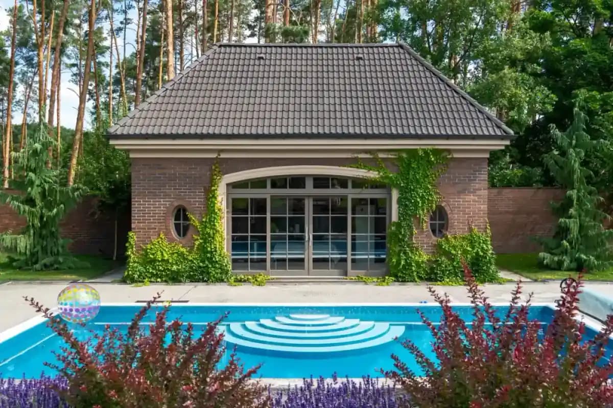 Finished garden building beside a landscaped pool and planting