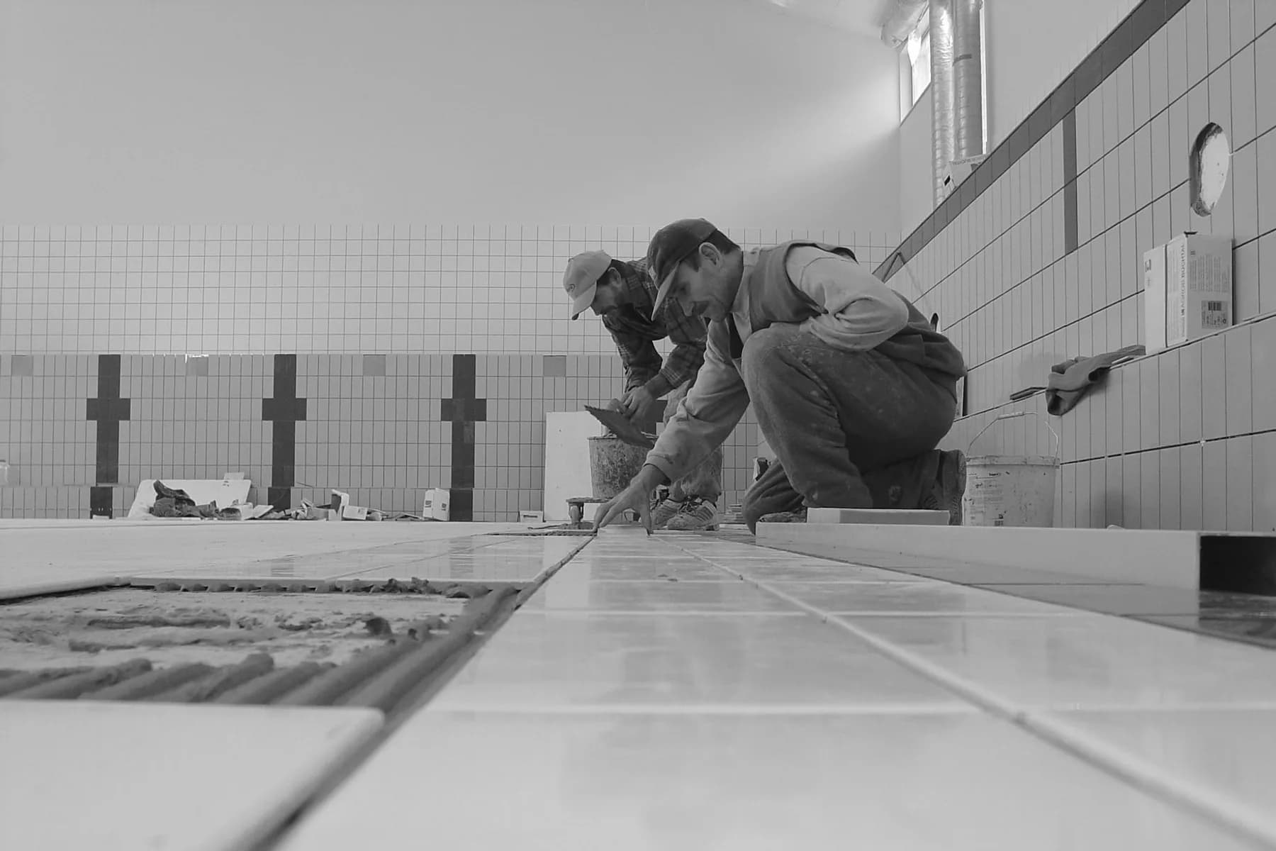 Bathroom fitters laying tiles during a renovation