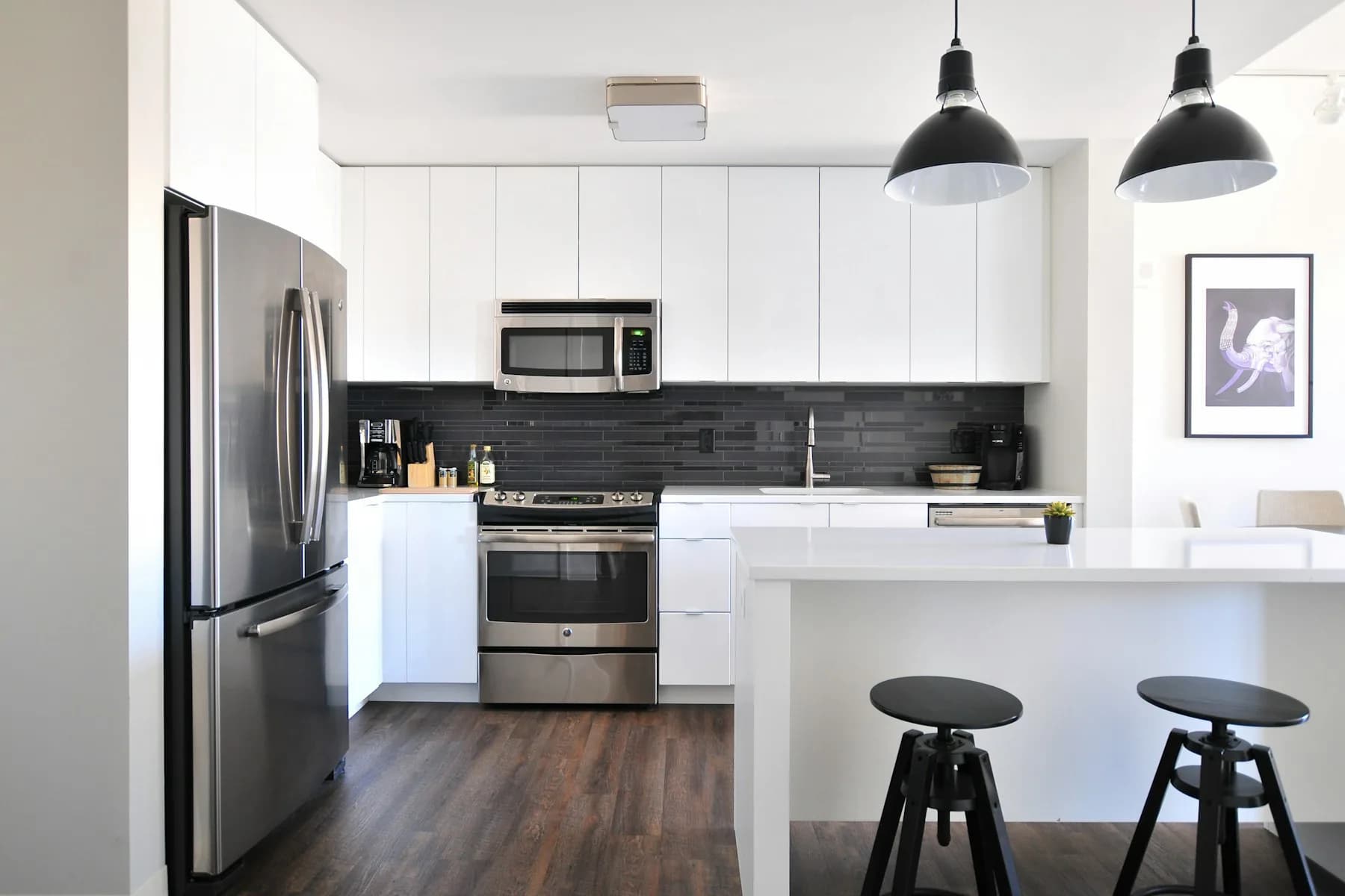 Finished kitchen with white cabinets, island, and stainless appliances